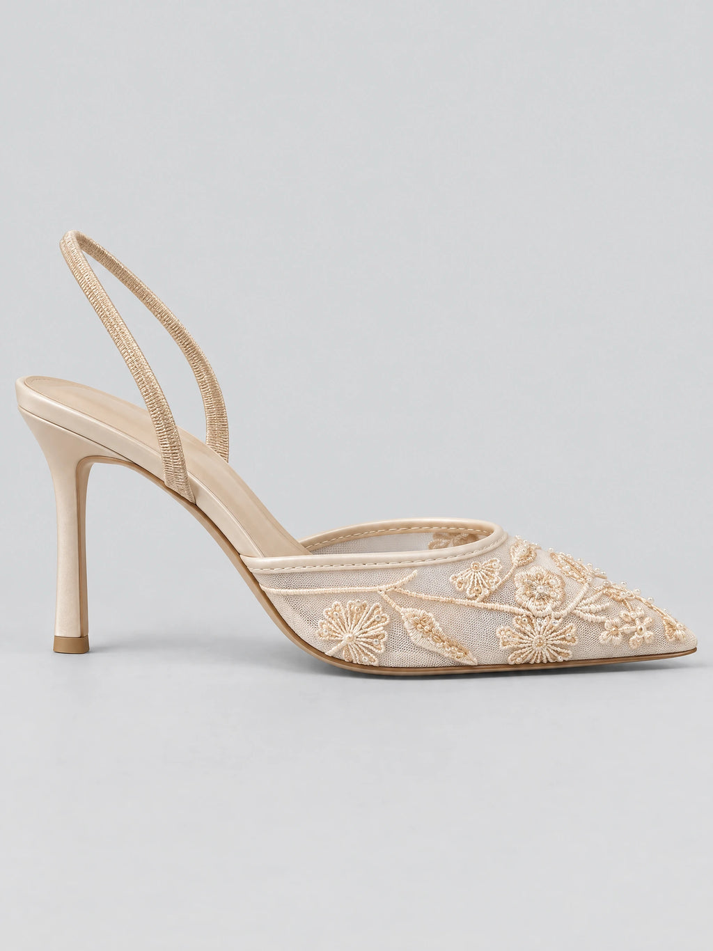 Side view of a Beige back strap slingback high heel with a sheer mesh upper, embroidered floral appliqués, and slim stiletto heel.