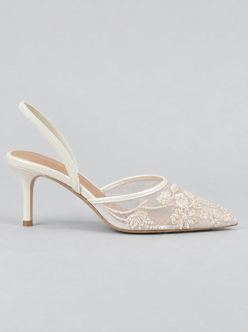 Side view of a White slingback high heel with a pointed mesh toe, floral embroidery, pearl embellishments, and a slim heel.
