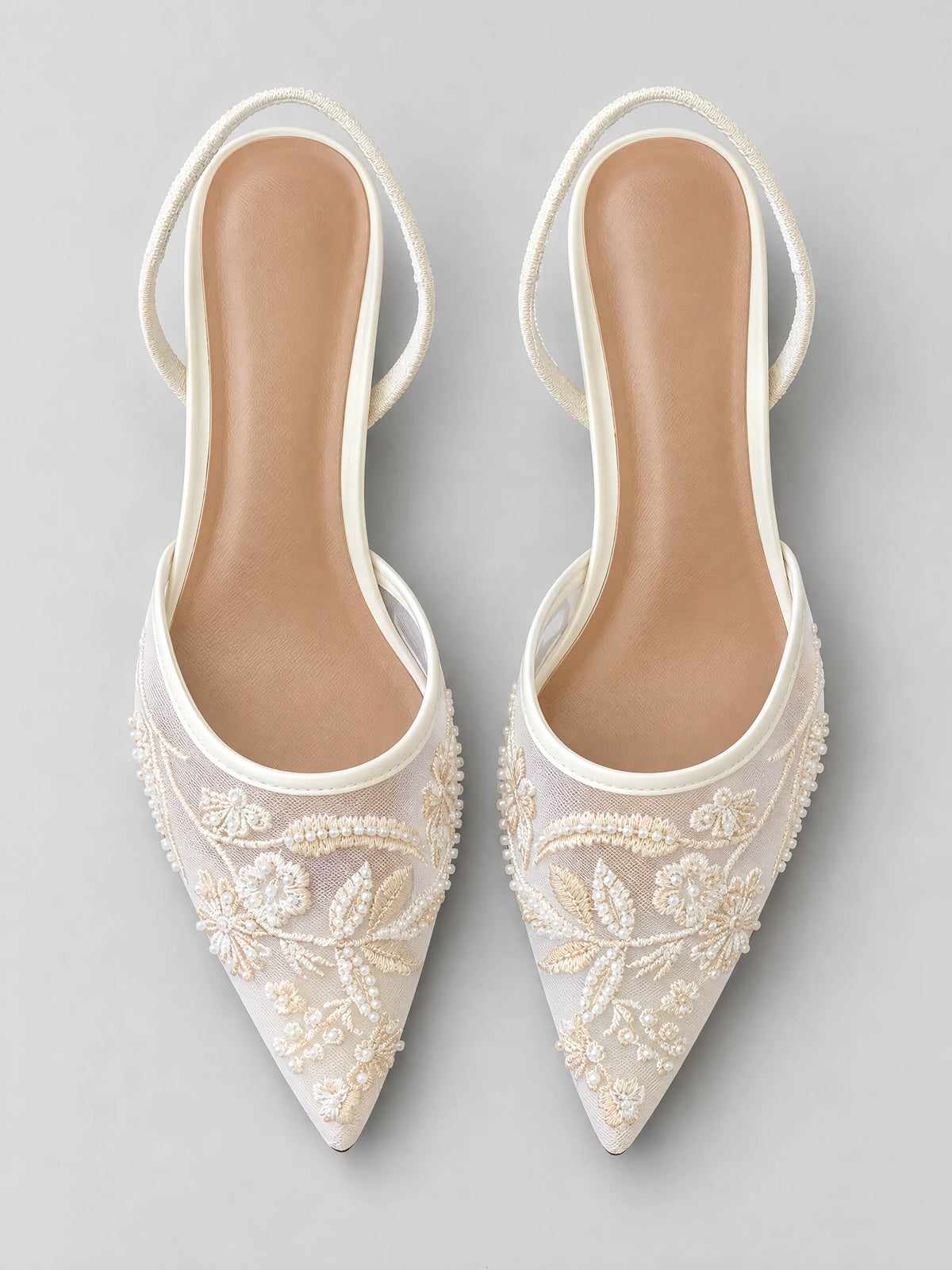 Top-down view of White back strap slingback high heels with pointed toes, embroidered floral mesh, and beaded embellishments.