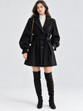 Front studio view of a model wearing a Black belted lantern sleeve wool coat with a notched lapel and button-front closure.