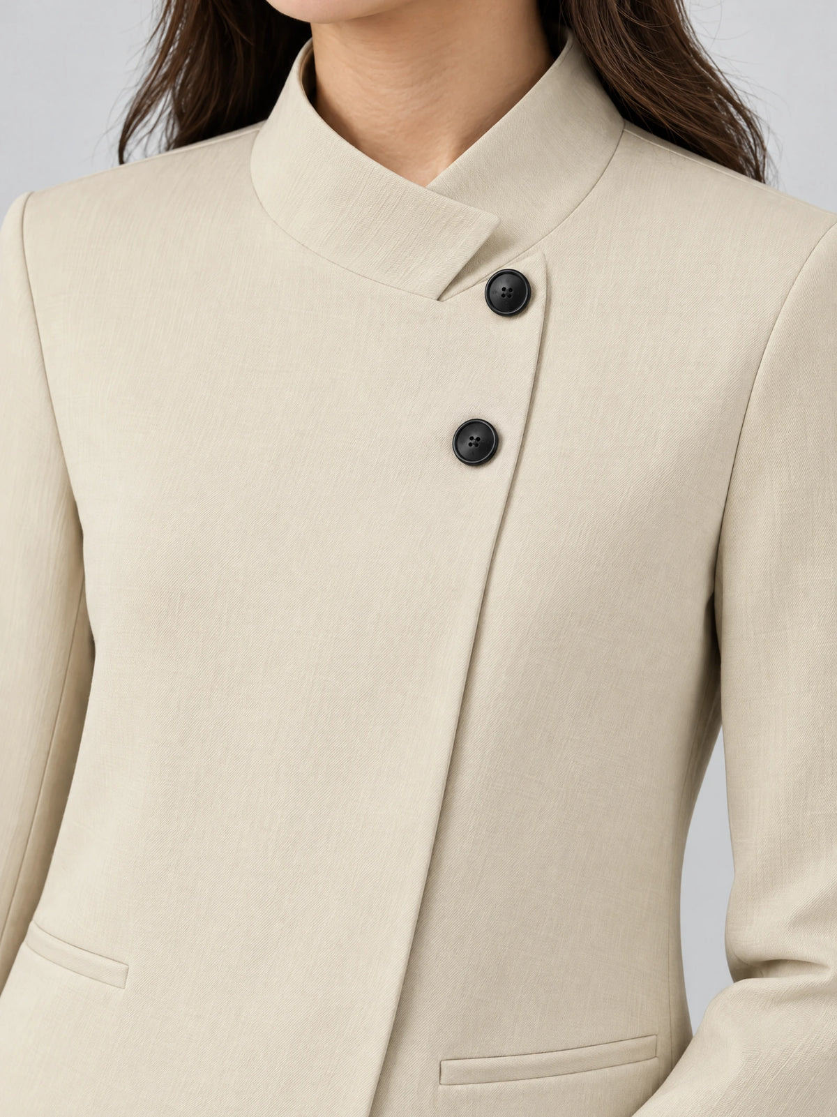 Close-up of a Beige Blazer Blouse showing the notched collar, dark buttons, and welt pockets.
