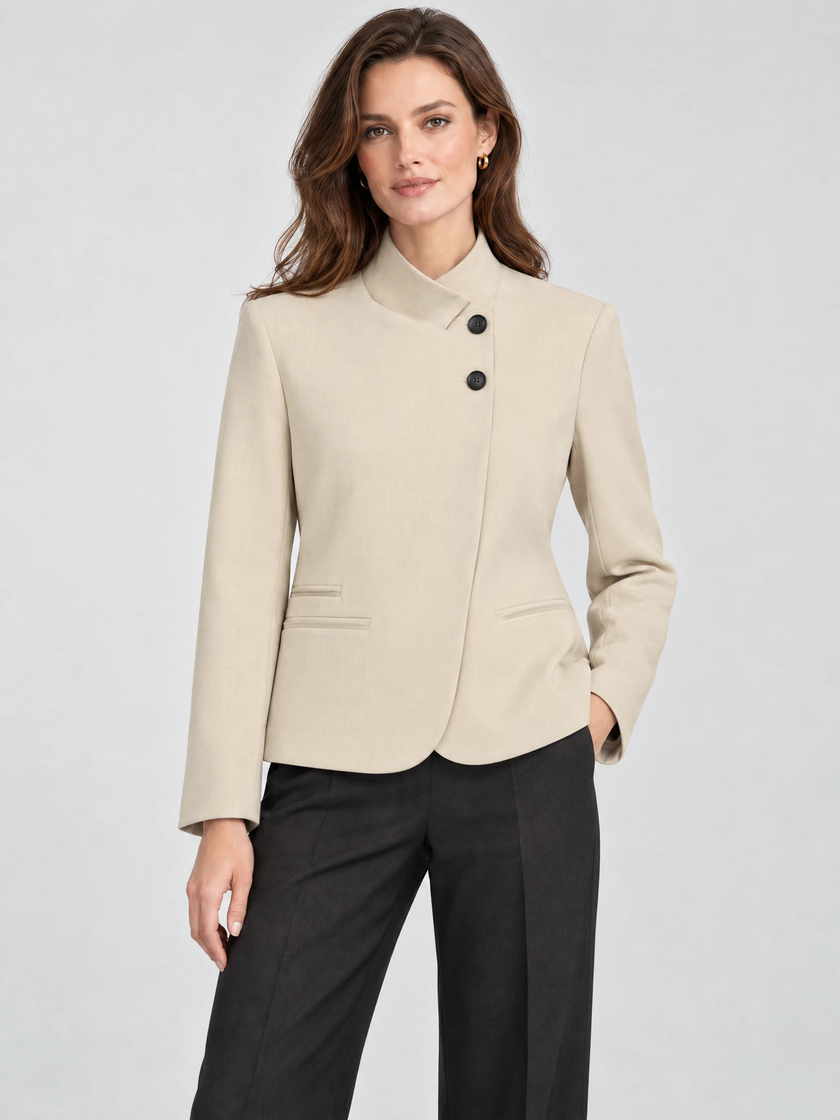 Front studio view of a model wearing a Beige Blazer Blouse with an asymmetric stand collar, dark buttons, and welt pockets.