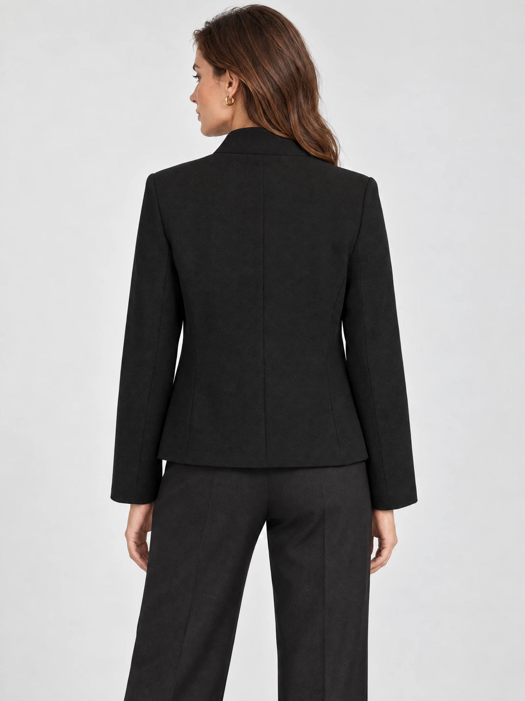 Rear studio view of a model wearing the Black Blazer Blouse, showing its tailored back seams and long sleeves.