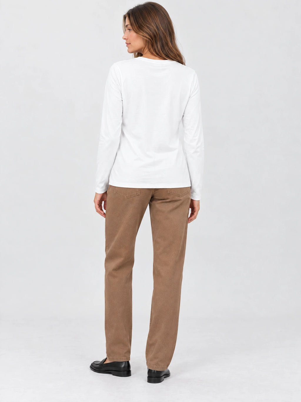 Back view of a model wearing a White cotton long sleeve T-shirt in a studio.