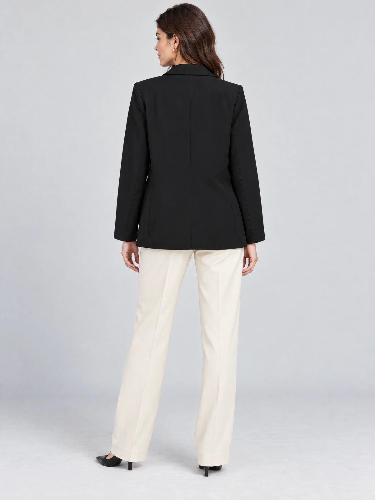 Rear studio view of a model wearing a Black Double Breasted Blazer with a tailored back seam and long sleeves.