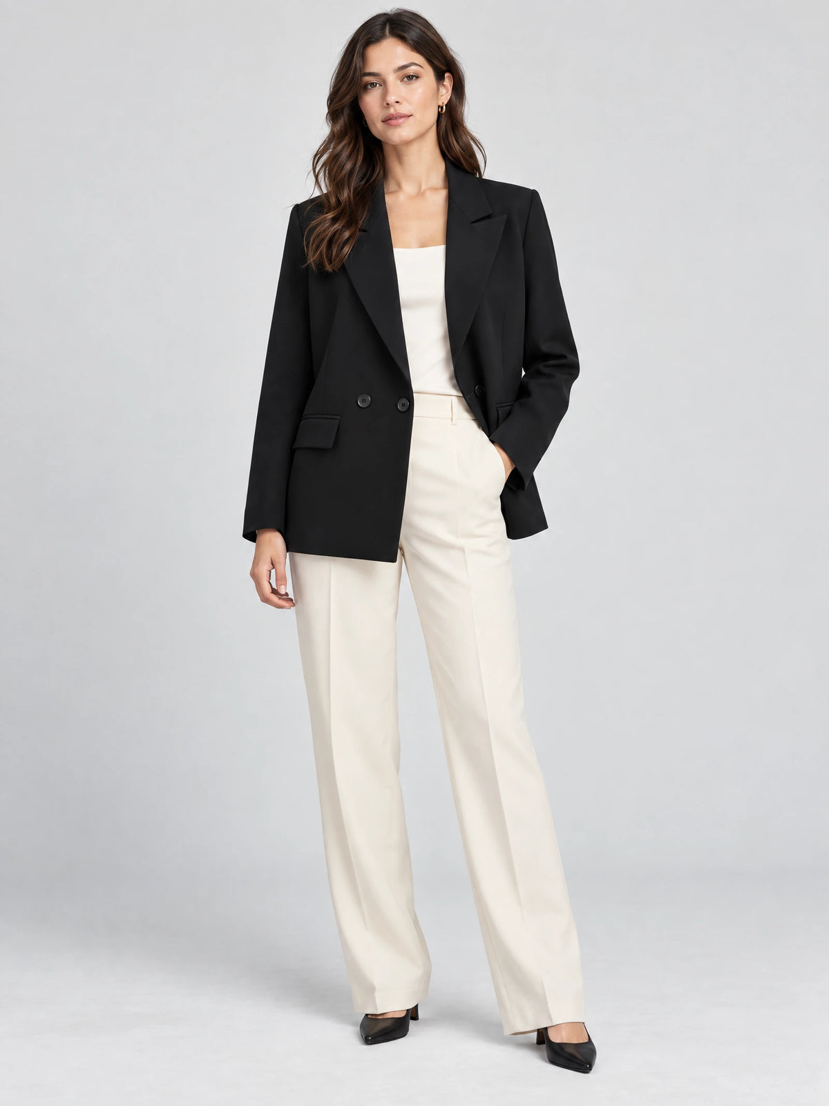 Model wearing a Black double breasted blazer with notched lapels and flap pockets in a front studio view.