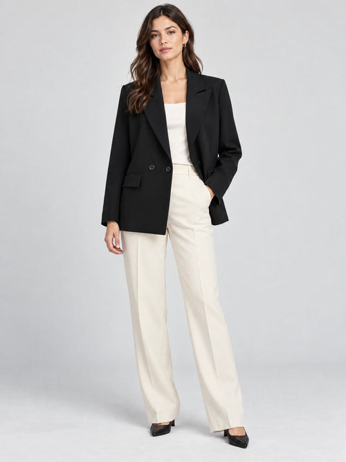 Model wearing a Black double breasted blazer with notched lapels and flap pockets in a front studio view.