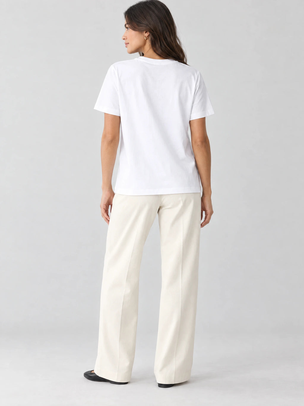 Rear studio view of a model wearing a White heavyweight cotton T-shirt with short sleeves and a straight hem.