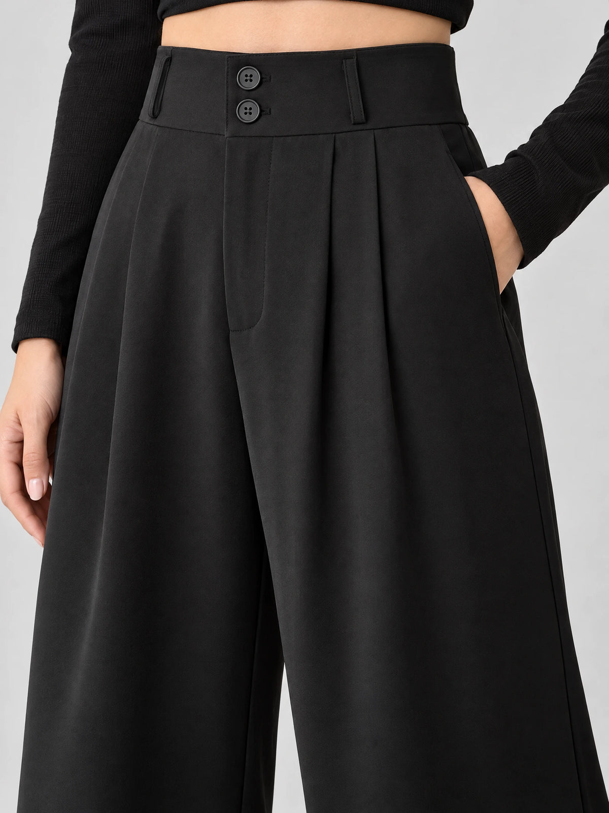 Close-up of Black high waist wide leg pants with a double-button waistband, front pleats, and side pockets.