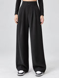 Front studio view of a model wearing Black high waist wide leg pants with a double-button waistband and front pleats.