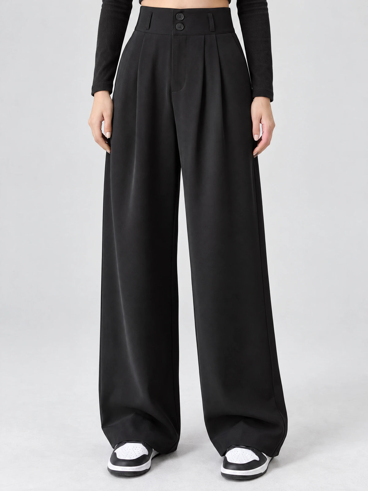 Front studio view of a model wearing Black high waist wide leg pants with a double-button waistband and front pleats.