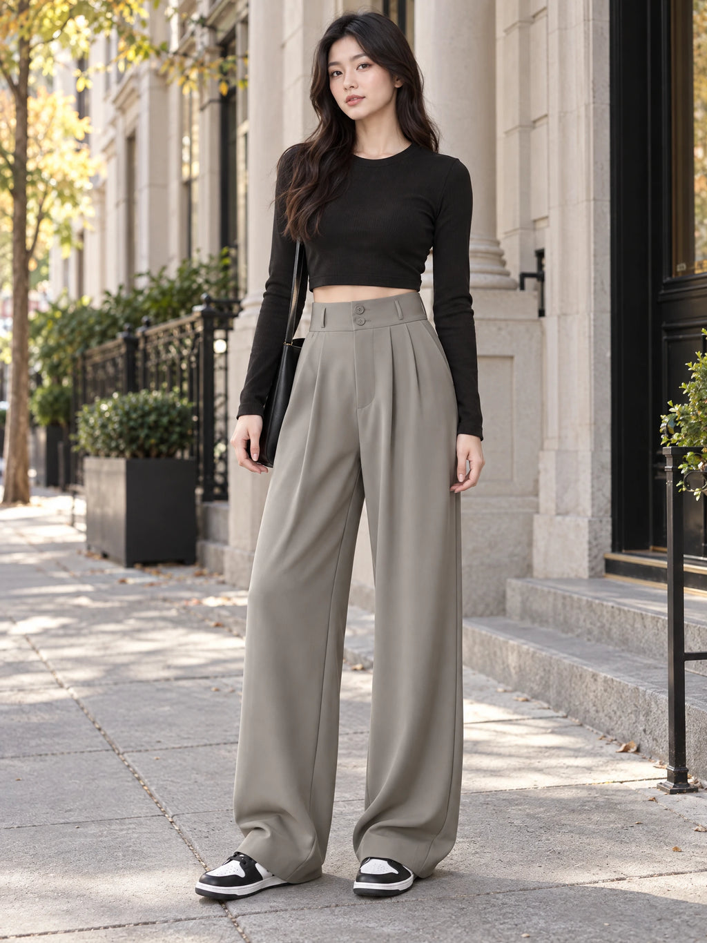 Model wearing Gray high waist wide leg pants with a buttoned waistband on a city sidewalk.