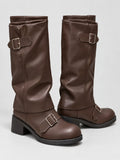 Brown leather knee-high chunky boots with buckle straps and block platform heels, shown in a studio product view.