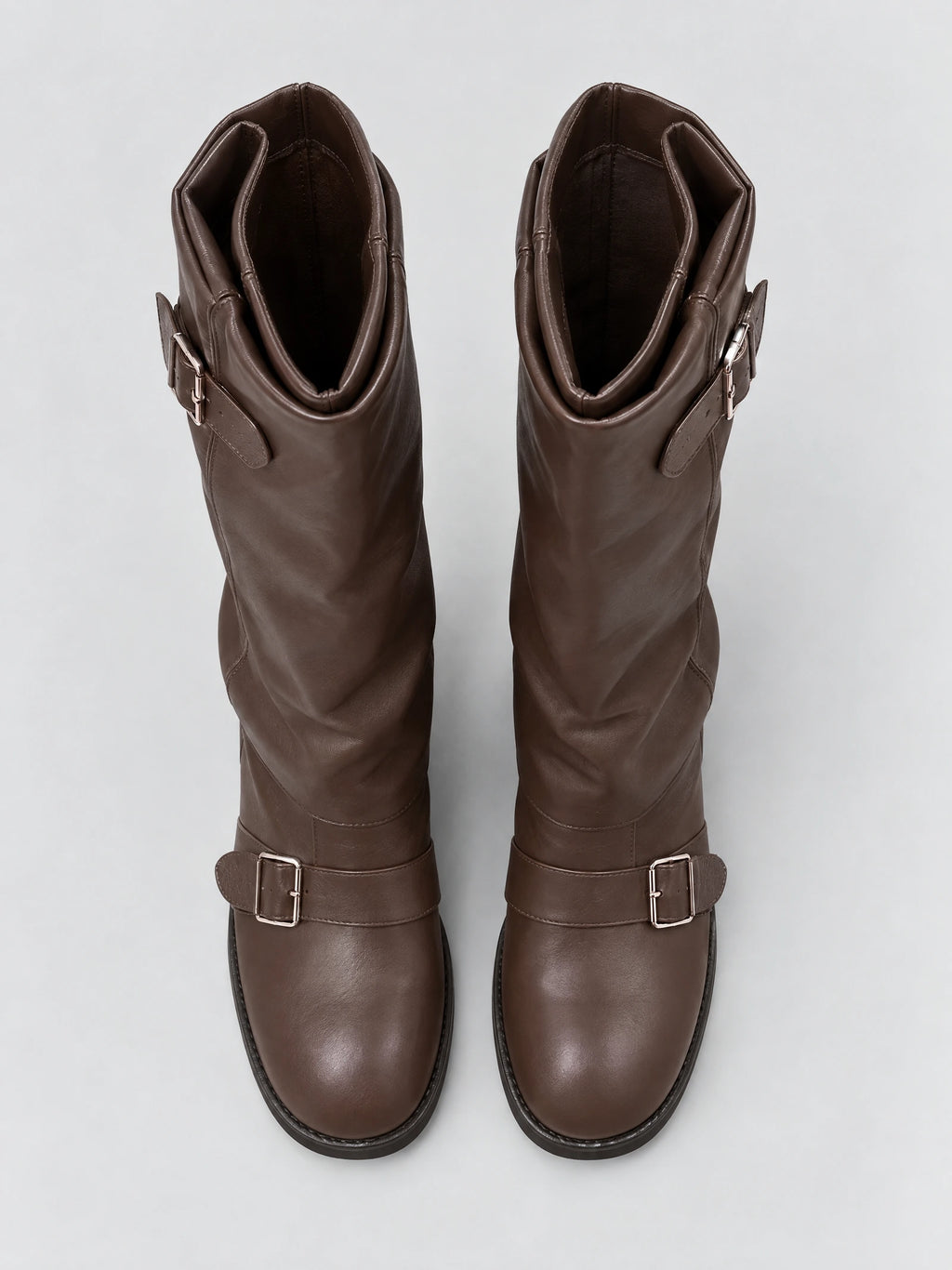 Top-down view of Brown leather knee high chunky boots with rounded toes, buckle straps, and folded shaft openings.