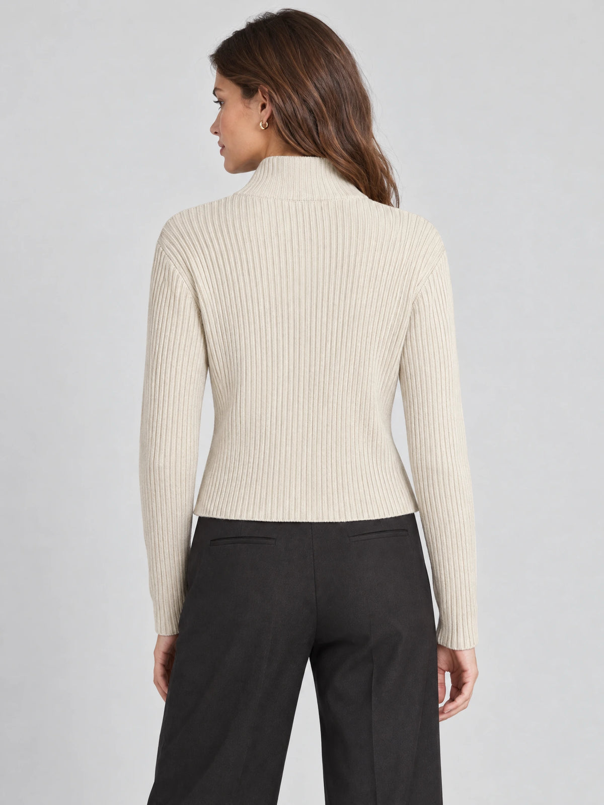 Back view of a model wearing a Beige ribbed Knit Cardigan with a high collar and long sleeves.