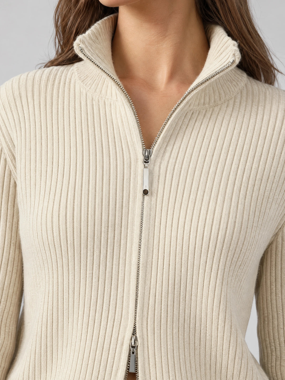 Close-up of the Beige Knit Cardigan showing ribbed texture, a stand collar, and two-way front zipper.