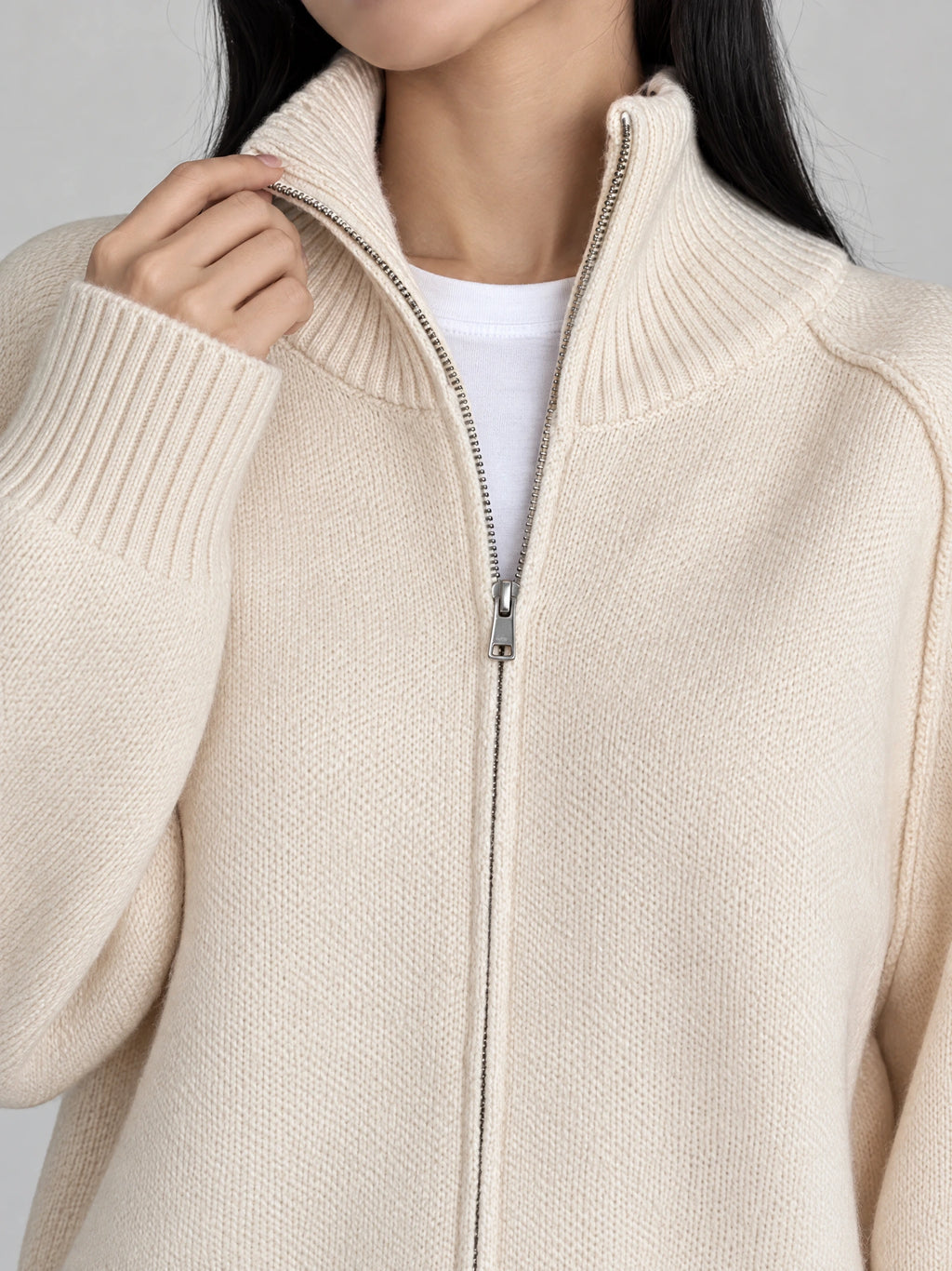 Close-up of Beige Knit Full Zip Sweater showing the ribbed stand collar, metal zipper, and knit texture.