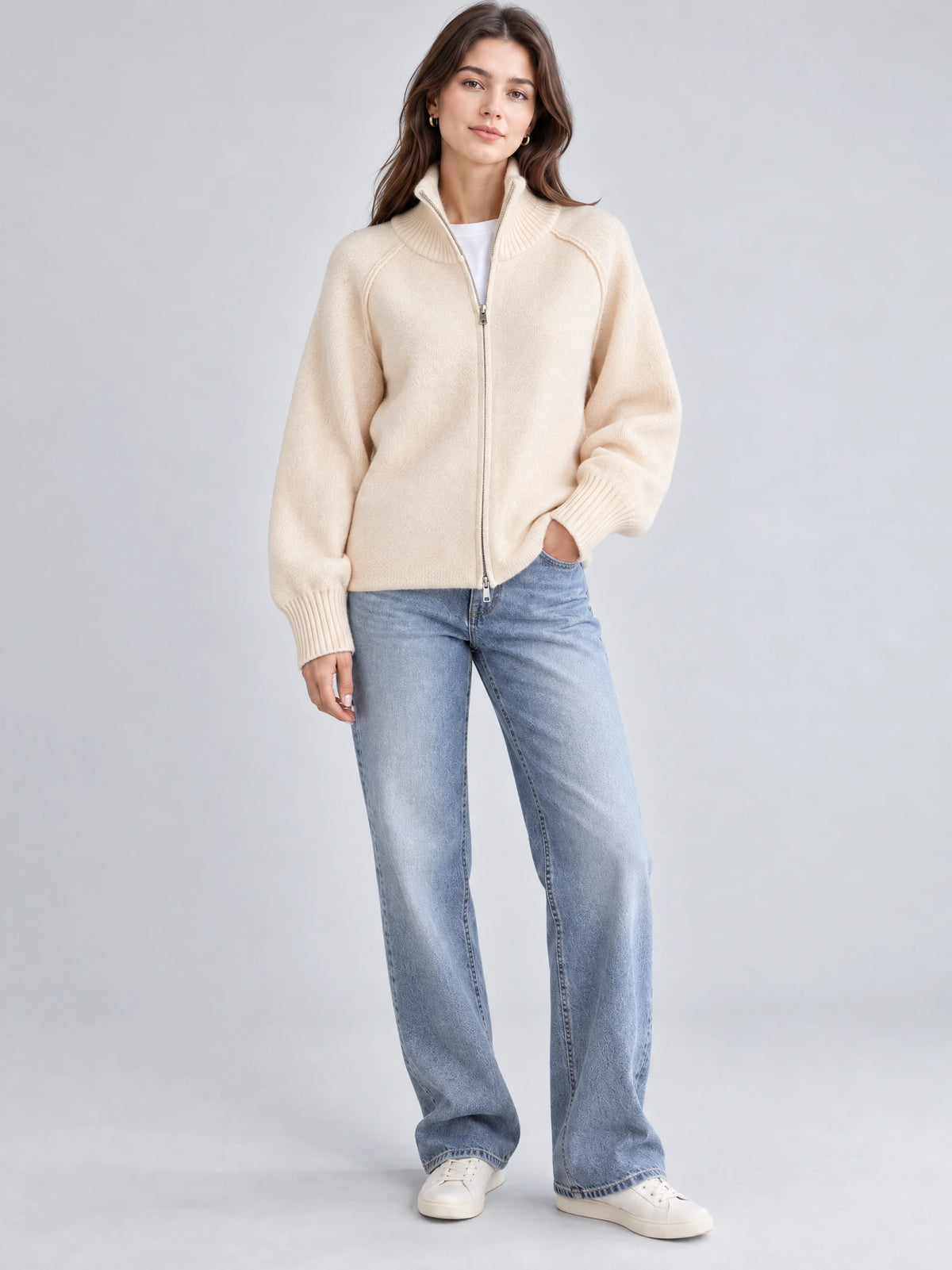 Front studio view of a model wearing a Beige knit full zip sweater with a ribbed stand collar and cuffs.