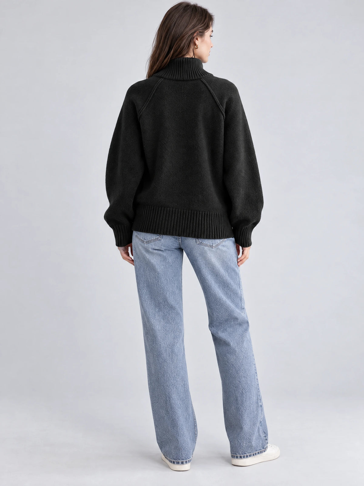 Rear studio view of a model wearing a Black Knit Full Zip Sweater with a ribbed collar, cuffs, and hem.