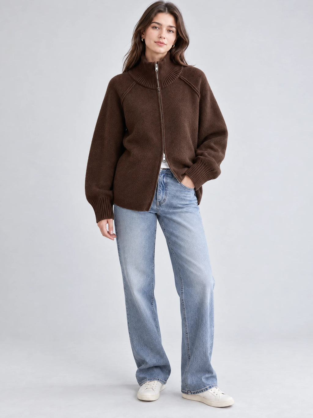 Model wearing a Brown knit full zip sweater with a ribbed high collar and cuffs in a front studio view.