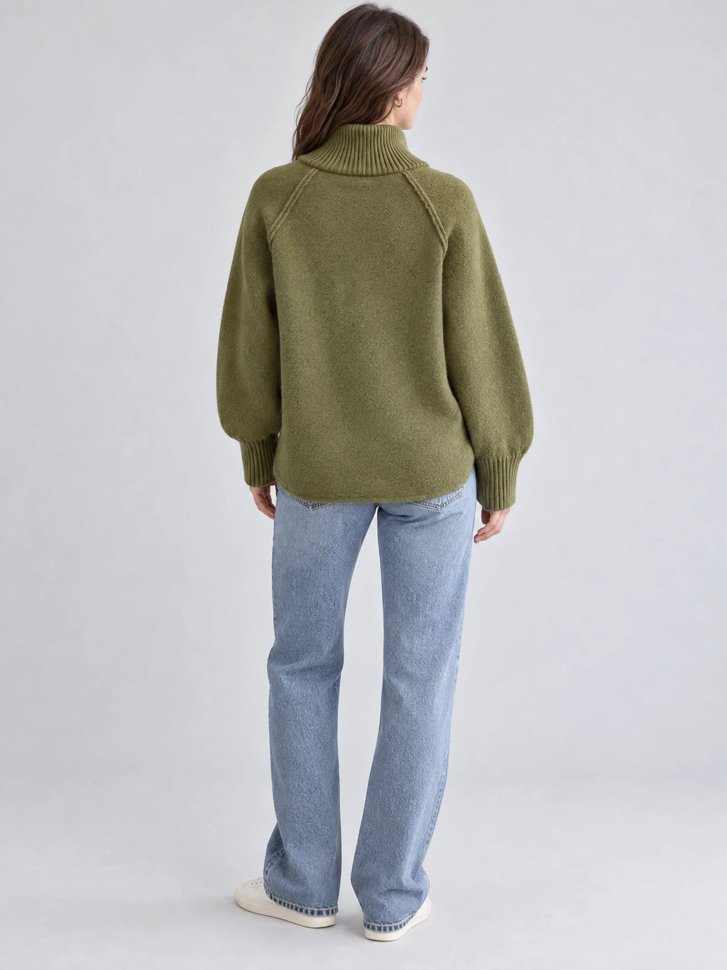 Back view of a model wearing the Green Knit Full Zip Sweater with a ribbed high collar, raglan seams, and ribbed cuffs.