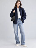 Model wearing a Navy knit full zip sweater with a ribbed stand collar and cuffs in a front studio view.