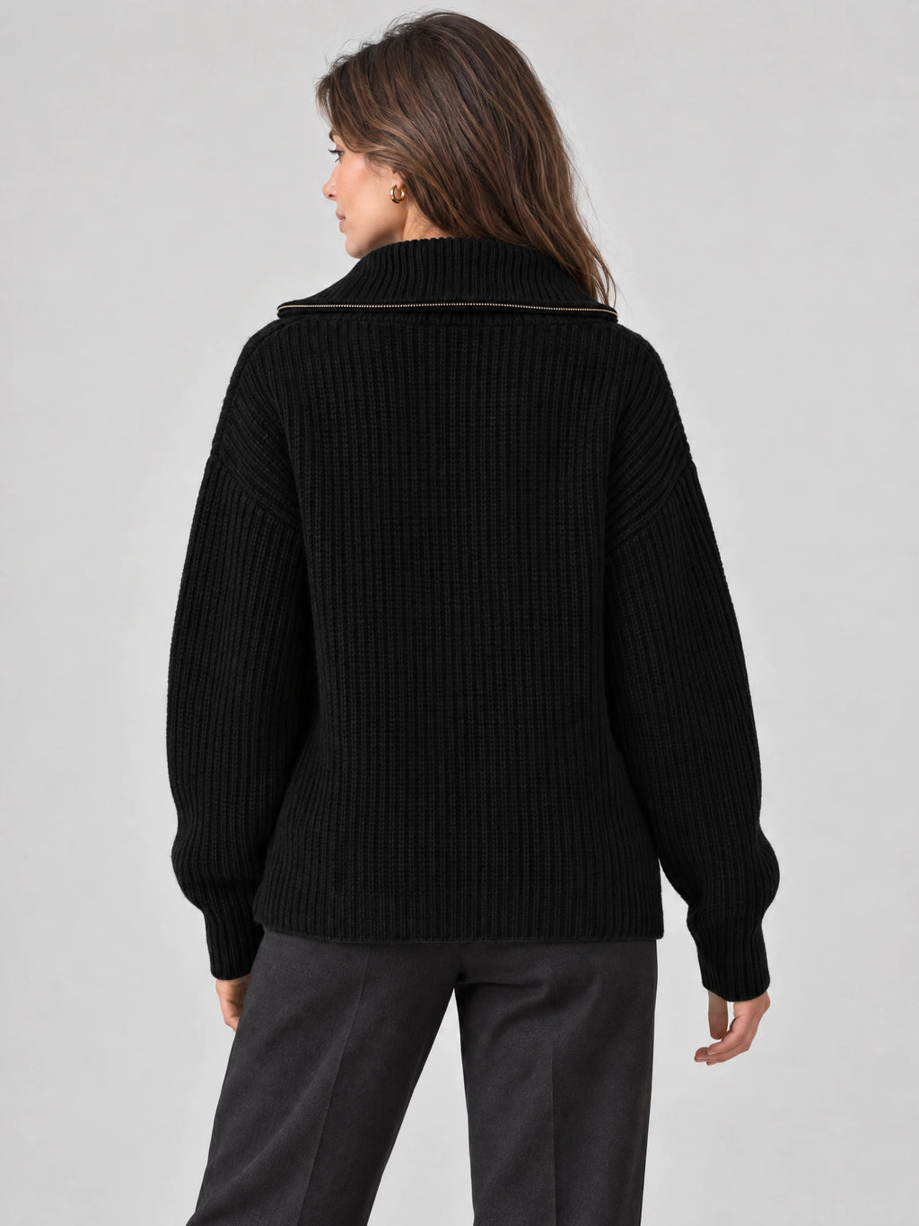 Rear view of a model wearing a Black Knit Turtle neck Cardigan with ribbed texture, relaxed sleeves, and a zip-trimmed high collar.