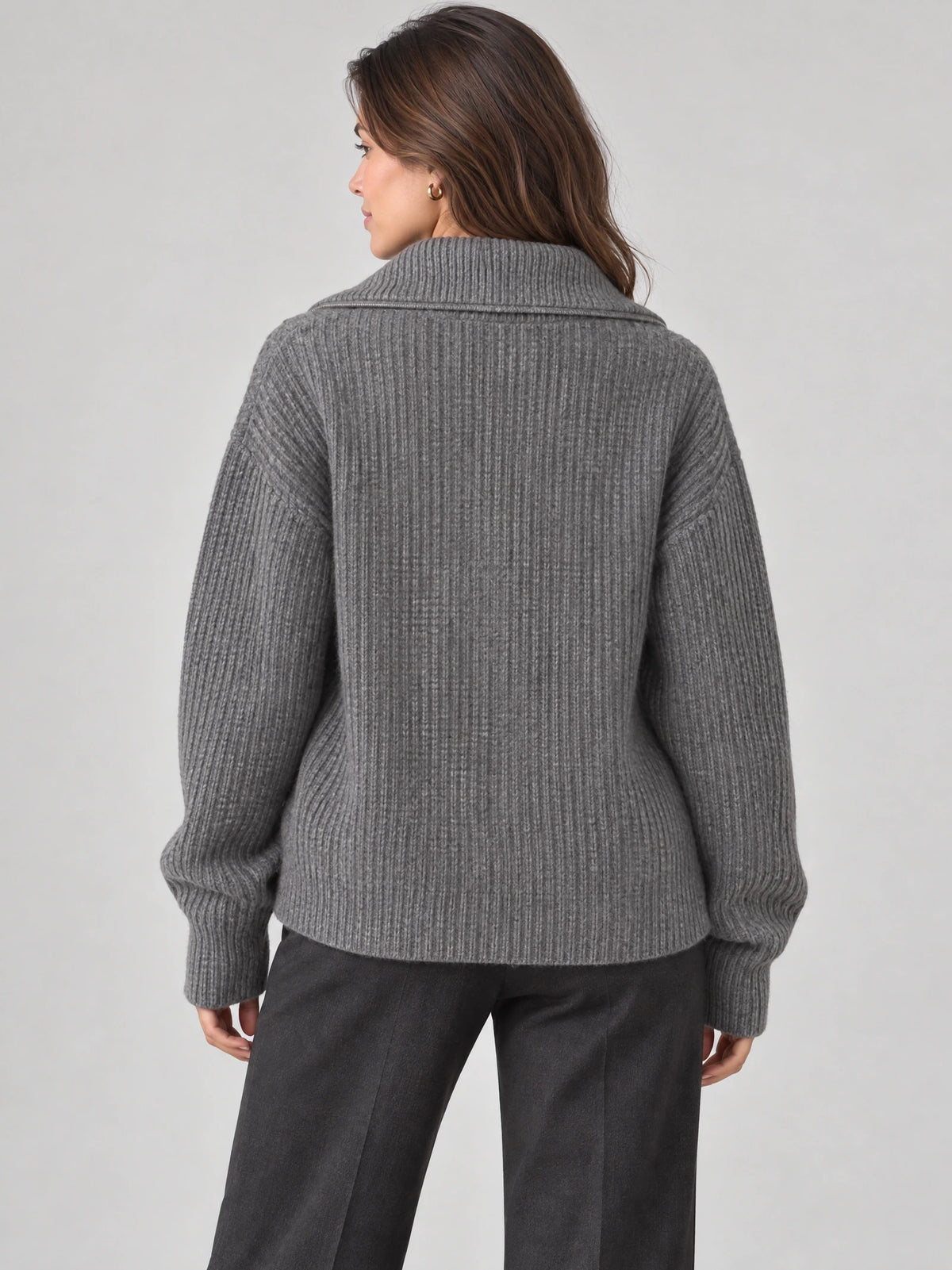 Rear view of a model wearing a Gray knit turtleneck cardigan with ribbed texture, dropped shoulders, and long cuffs.