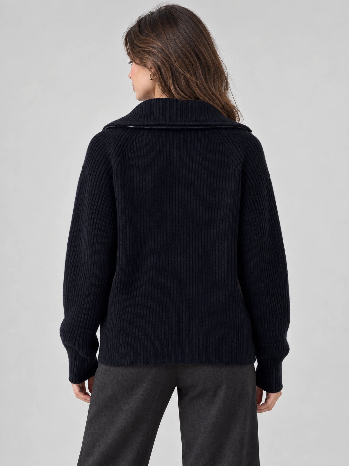 Rear view of a model wearing a Navy ribbed knit turtleneck cardigan with a wide folded collar and long sleeves.