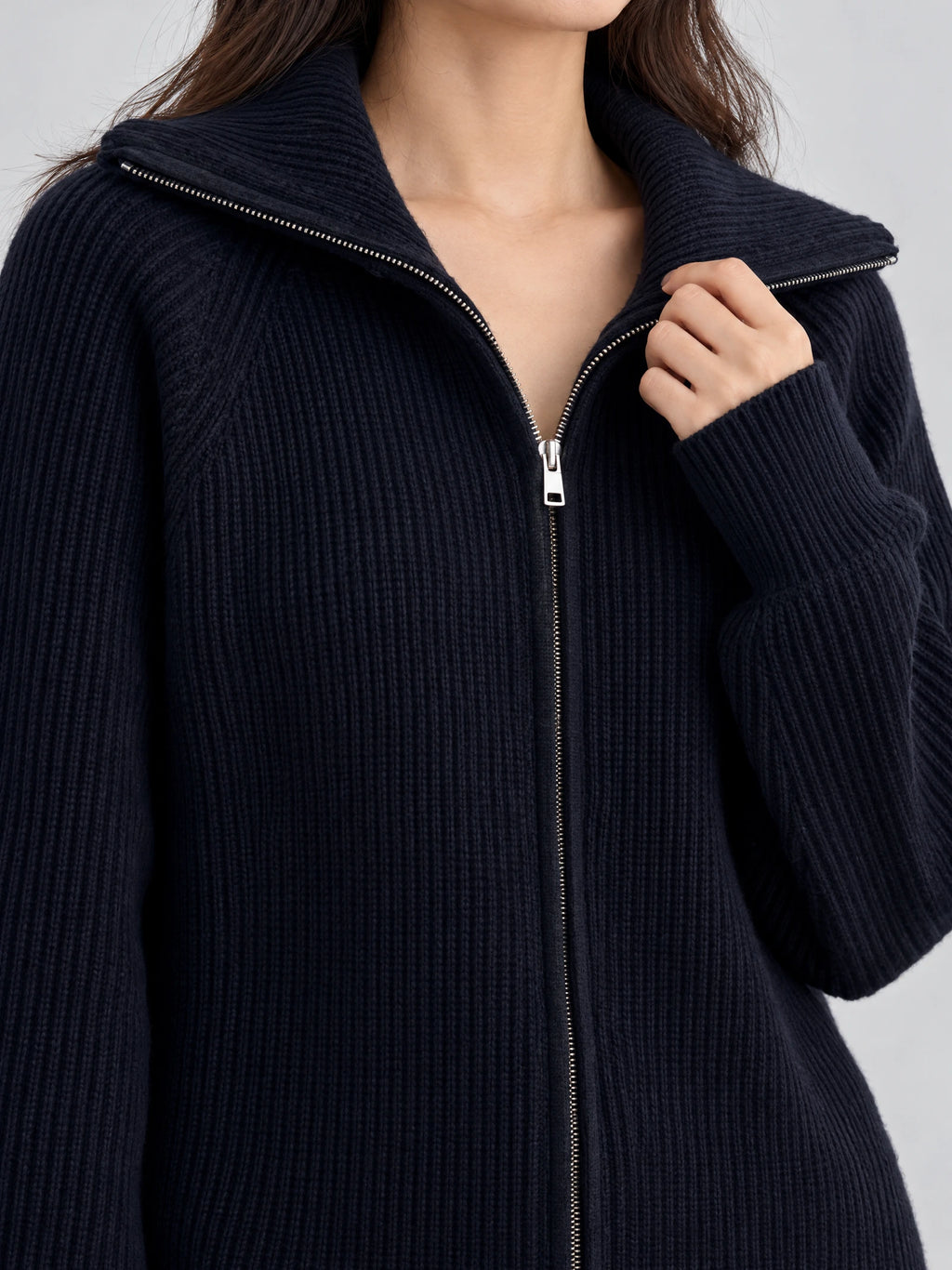 Close-up of the Navy Knit Turtle neck Cardigan showing its ribbed texture, wide collar, and silver front zipper.