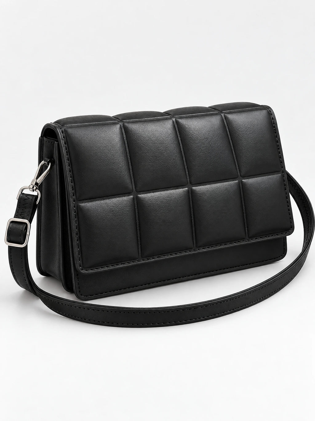 Black leather cross body bag shown at an angle with a padded grid front panel and adjustable strap.