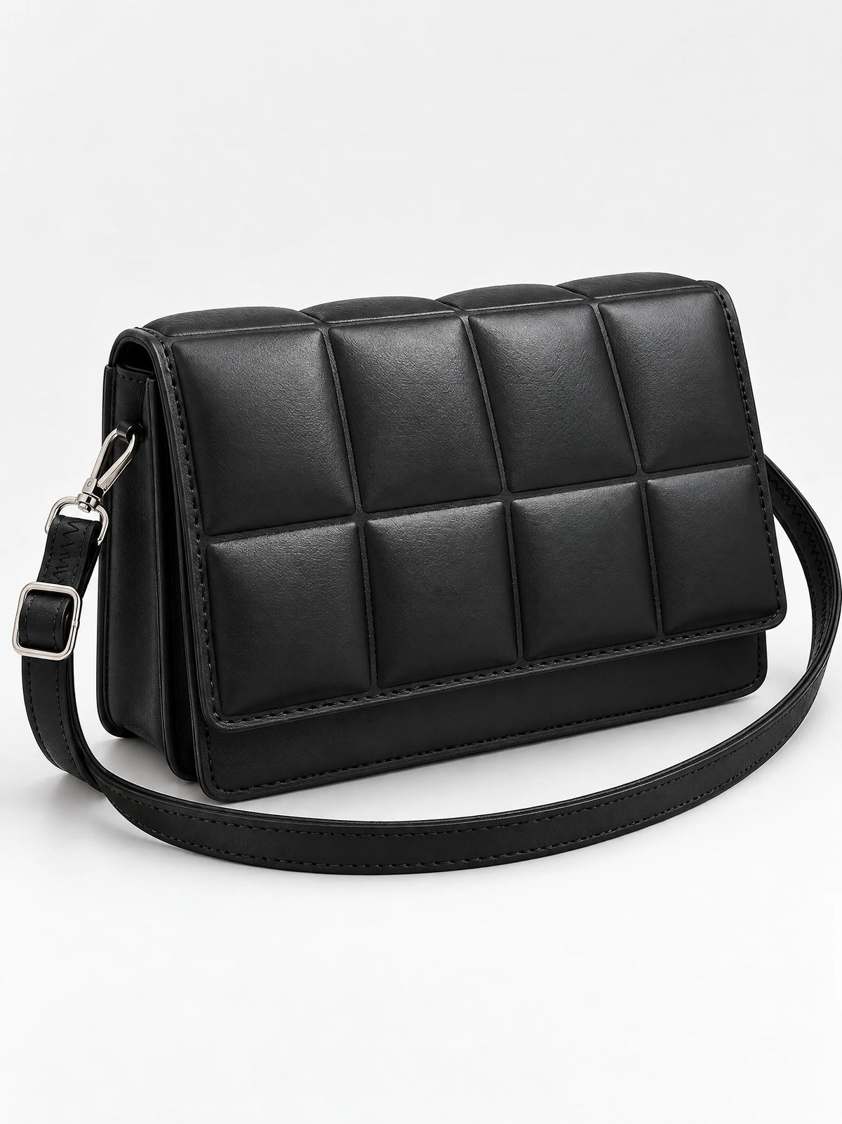 Black leather cross body bag shown at an angle with a padded grid front panel and adjustable strap.