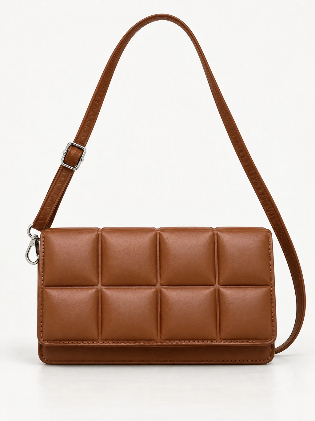 Brown leather cross body bag shown front-on with a padded panel design, adjustable strap, and metal hardware.