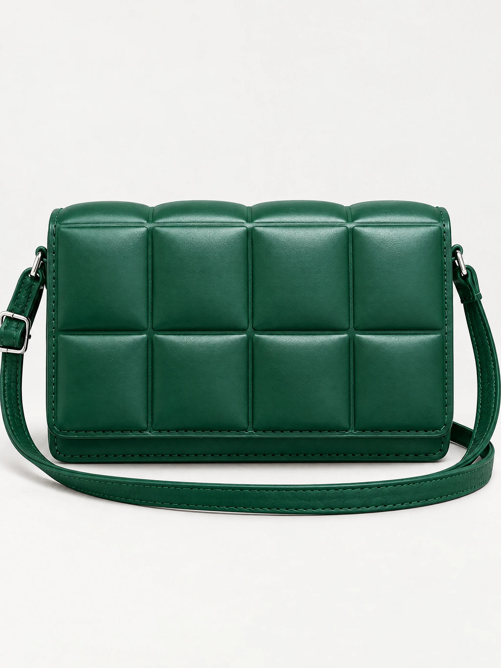 Green leather cross body bag with a padded grid front, adjustable strap, and metal hardware in a front studio view.