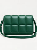 Green leather cross body bag with a padded grid front, adjustable strap, and metal hardware in a front studio view.