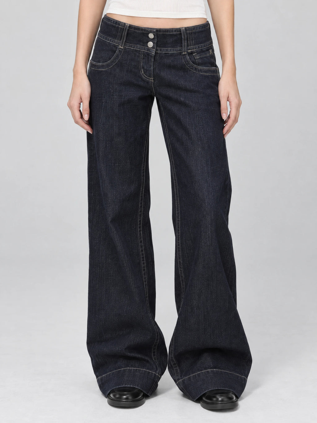 Front studio view of a model wearing Blue Lowe Rise Jeans with a wide-leg fit, contrast stitching, and two-button waistband.