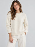 Model wearing a Beige women’s mohair winter sweater with a ribbed crew neckline, cuffs, and hem in a front studio view.