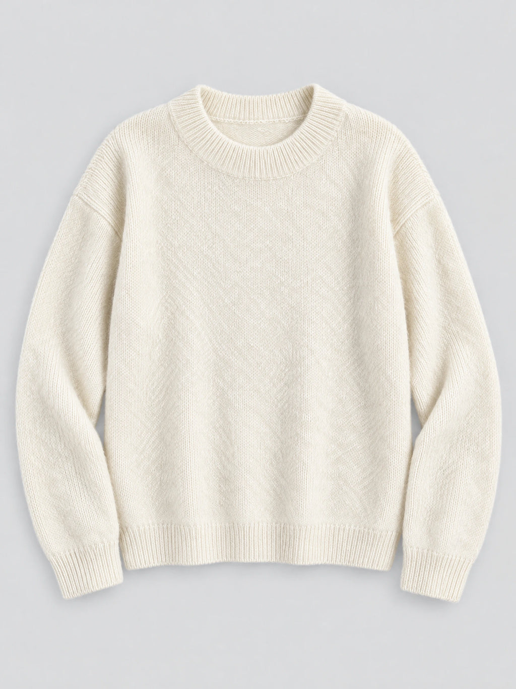 Beige women's mohair winter sweater laid flat, featuring a ribbed crew neckline, cuffs, and hem.