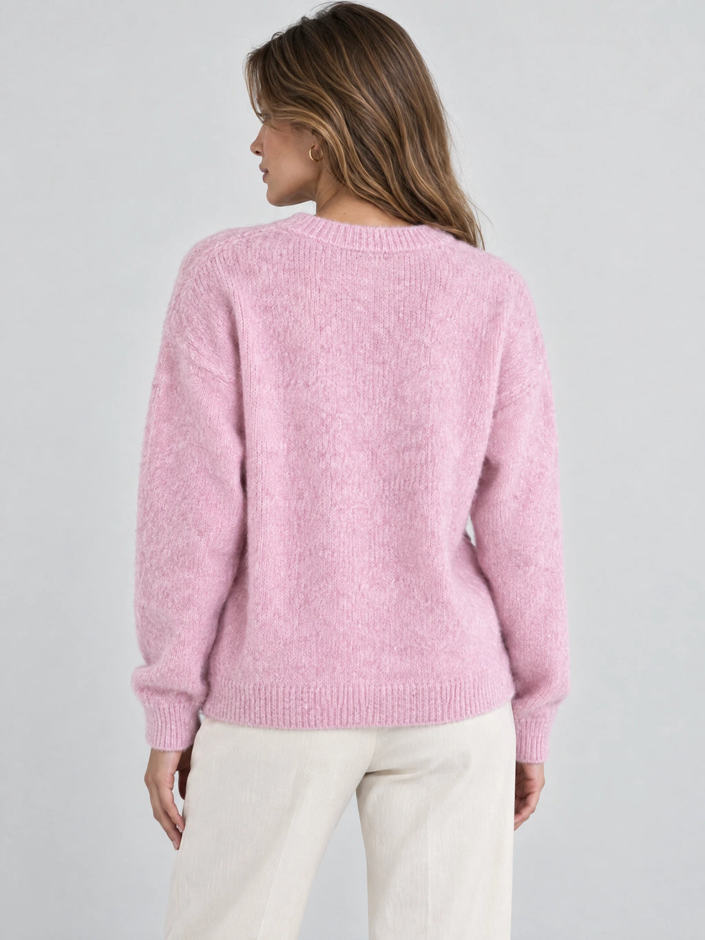 Back view of a model wearing a Pink women’s mohair winter sweater with a ribbed crew neckline, cuffs, and hem.