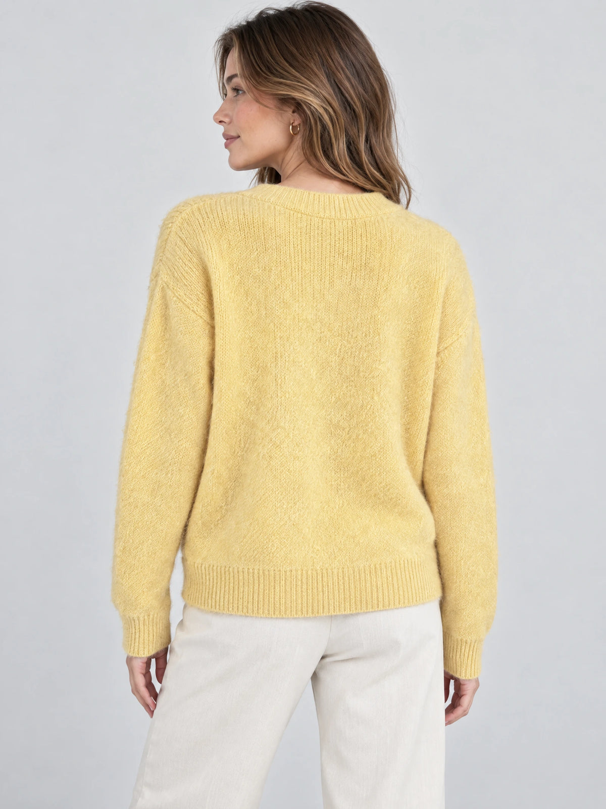 Rear studio view of a model wearing the Yellow Women Mohair Winter Sweater with a ribbed crew neckline, cuffs, and hem.