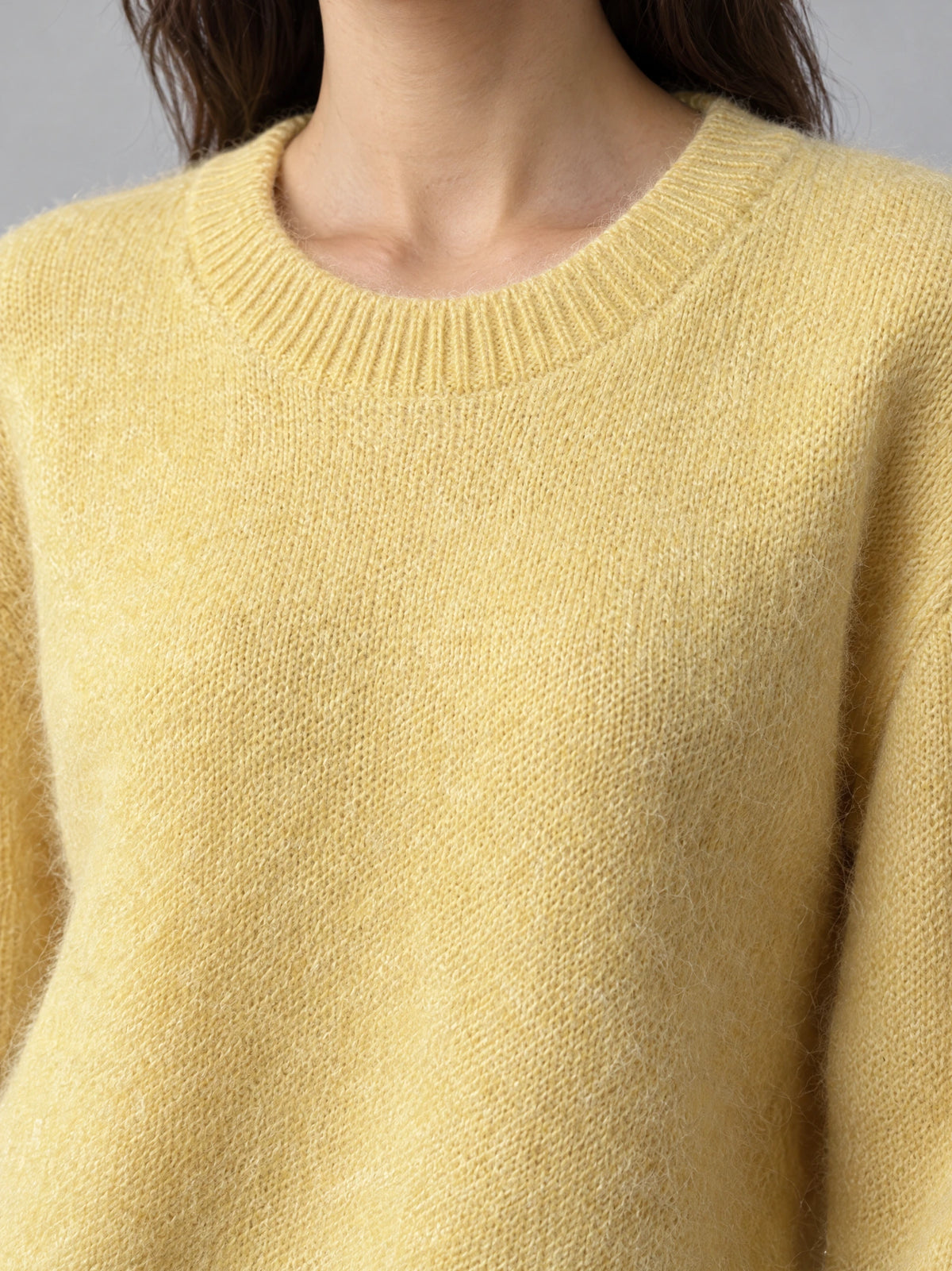 Close-up of the Yellow Women Mohair Winter Sweater showing its ribbed crew neckline and softly fuzzy knit texture.