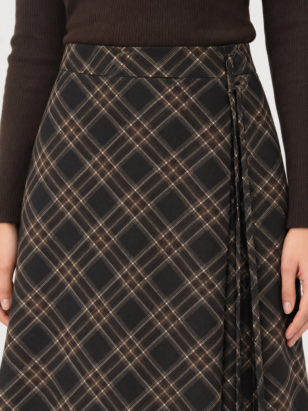 Close-up of the Brown Pleated A-line Skirt with a diagonal check pattern, wide waistband, and side tie detail.