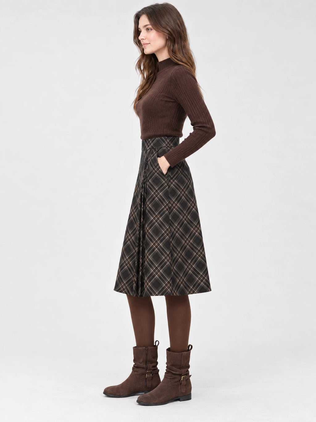 Side studio view of a model wearing a Brown pleated A-line skirt with a high waistband and side pocket.