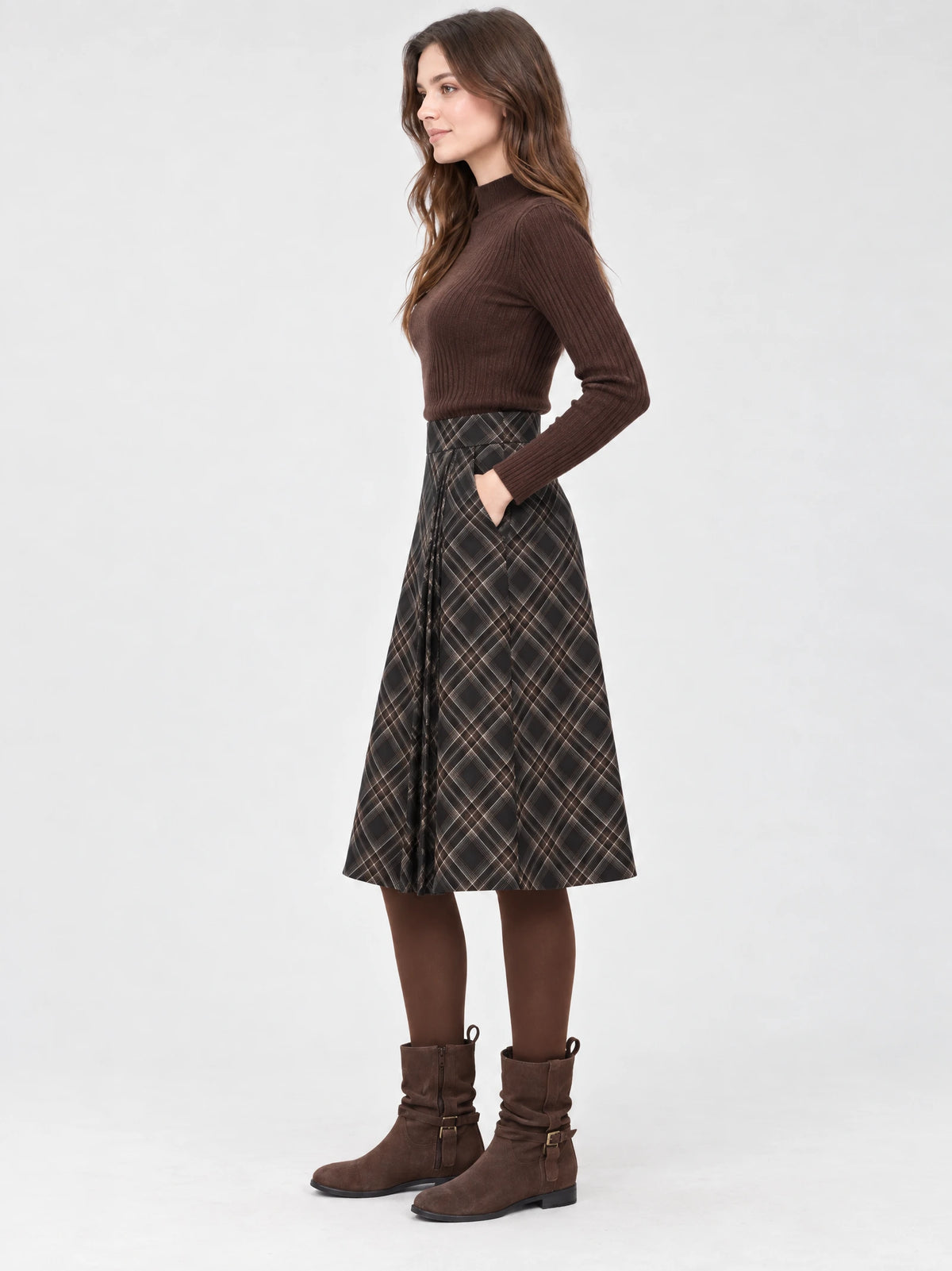 Side studio view of a model wearing a Brown pleated A-line skirt with a high waistband and side pocket.