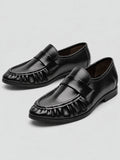 Black ruched leather loafers shown as a pair in a studio product photo, with moc-toe stitching and low flat heels.