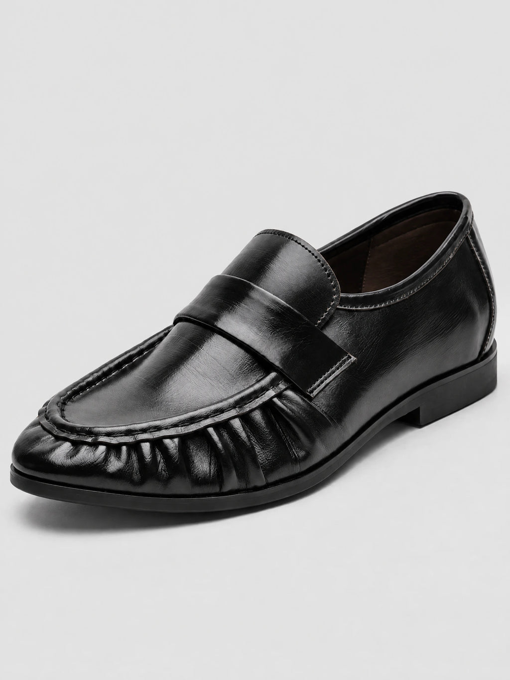 Three-quarter view of Black ruched leather loafers with a round toe, stitched vamp, and low block heel.