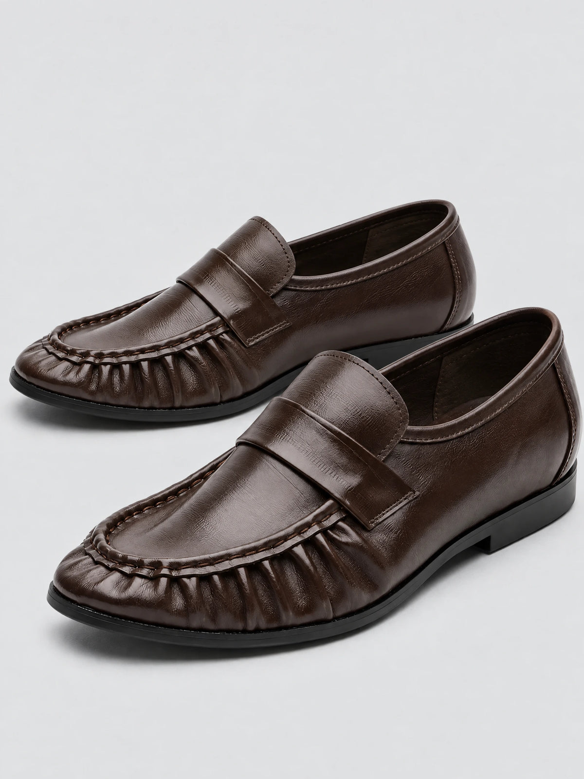 Brown ruched leather loafers shown as a pair in a front studio product view.