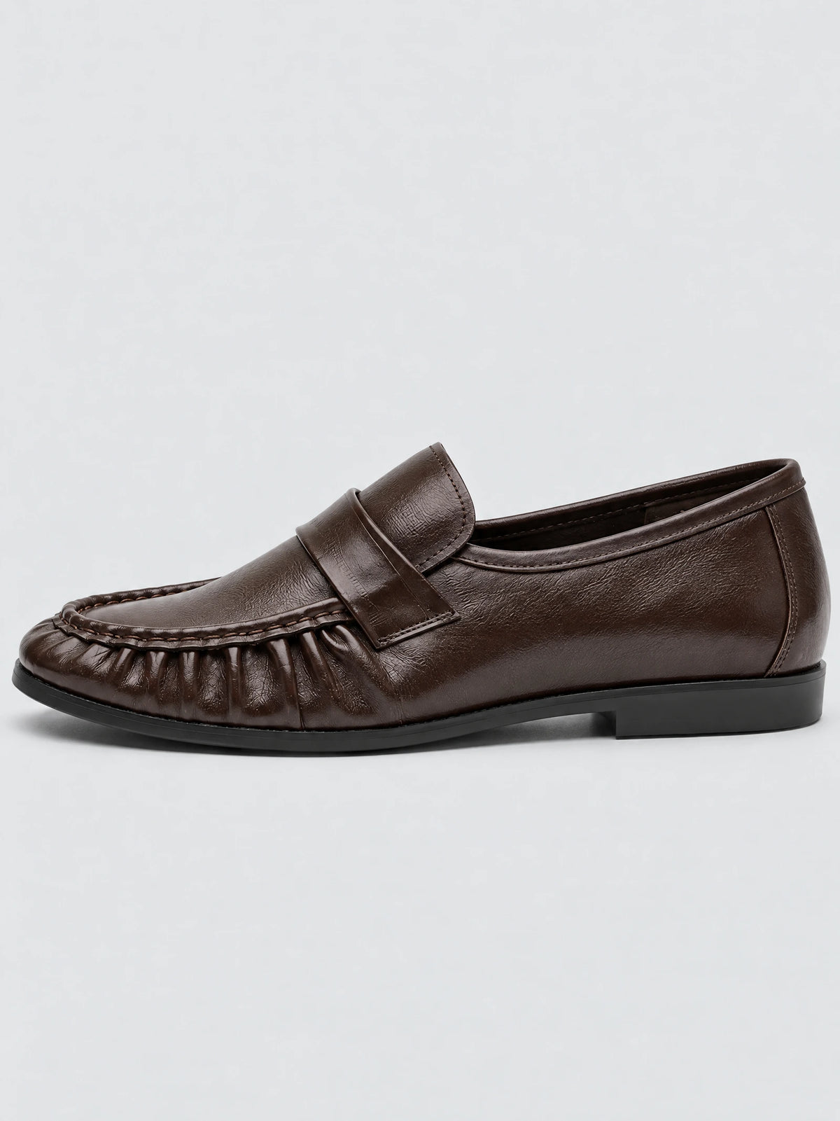 Side view of a Brown ruched leather loafer with stitched moc toe, strap detail, and flat heel.