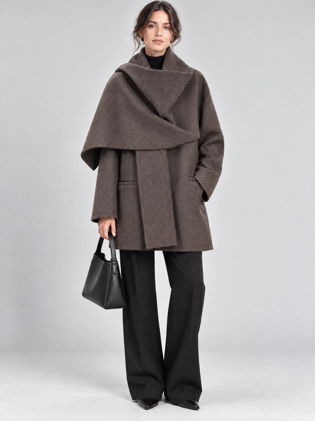 Front studio view of a model wearing a Brown wool coat with an oversized scarf collar and front pockets.