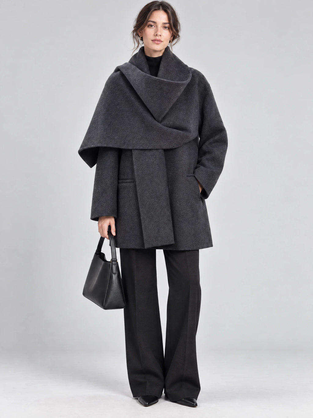 Front studio view of a model wearing a Gray wool coat with an oversized scarf collar and front pockets.